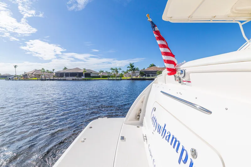 Slide: The Image of Tiara Yachts 4300 Sovran 2011 on water, American flag, sunny day, waterfront homes. - 11