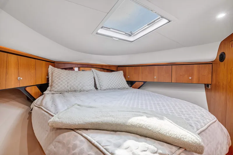 Slide: The Image of Luxurious cabin interior of 2011 Tiara Yachts 4300 Sovran with cozy bedding and wooden cabinets. - 29