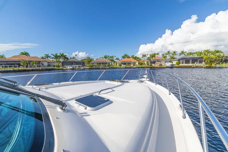 Slide: The Image of 2011 Tiara Yachts 4300 Sovran cruising on a sunny day near waterfront homes. - 3