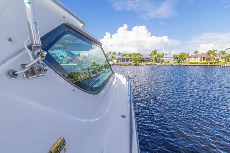Slide: The Image of 2011 Tiara Yachts 4300 Sovran on a serene waterfront with clear skies. - 4