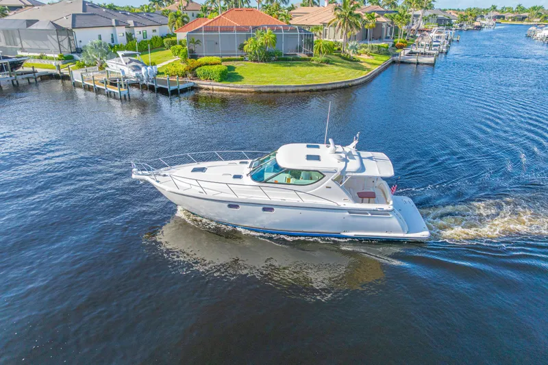 Slide: The Image of 2011 Tiara Yachts 4300 Sovran cruising in a scenic waterfront neighborhood. - 9