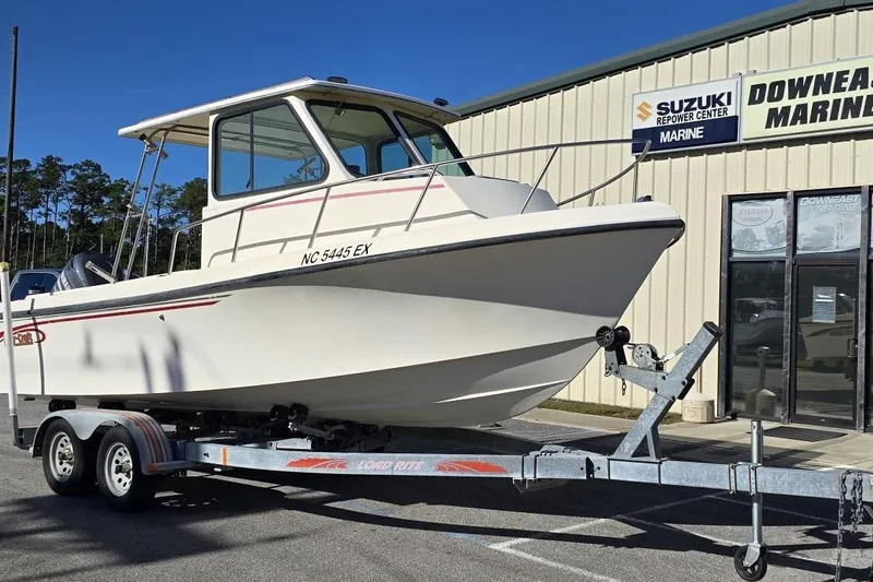 Slide: The Image of 2000 Maycraft Pilot House 2300 boat on trailer at marine center. - 1