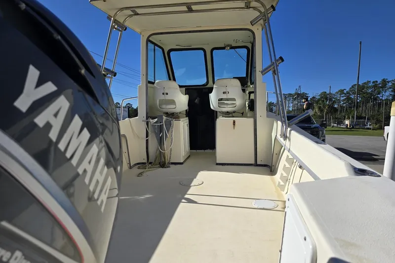 Slide: The Image of 2000 Maycraft Pilot House 2300 boat interior with Yamaha engine, featuring seating and controls. - 3