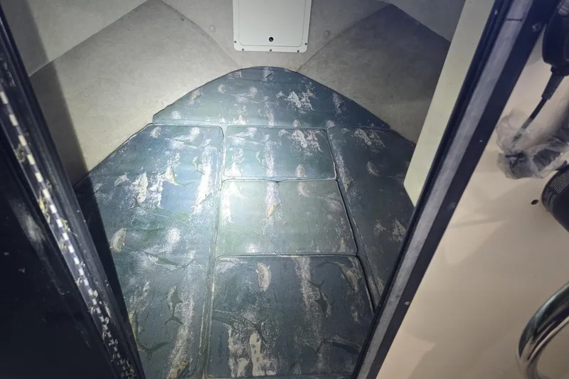 Slide: The Image of Interior cabin of 2000 Maycraft Pilot House 2300 boat, featuring cushioned seating. - 5