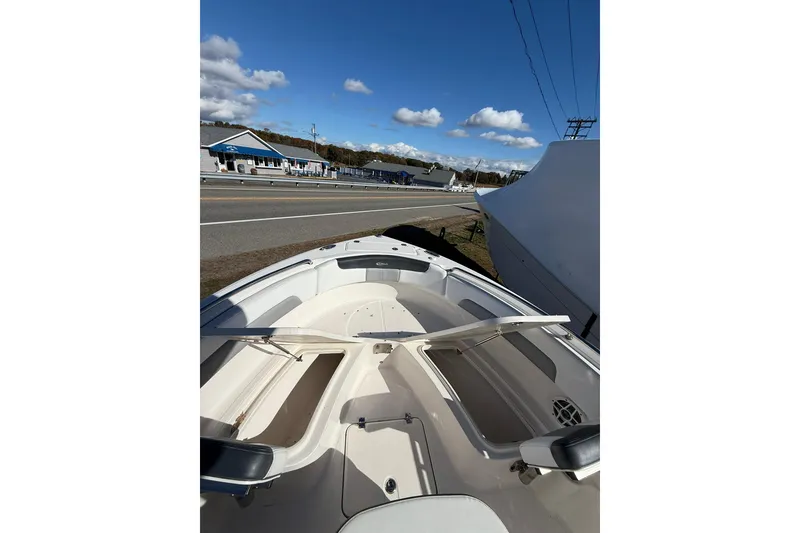 Slide: The Image of 2021 Robalo R222 Explorer boat interior with open storage compartments, parked roadside. - 10