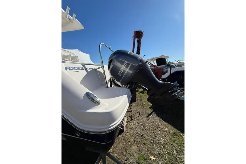 Slide: The Image of 2021 Robalo R222 Explorer boat with Yamaha outboard motor, parked outdoors. - 17