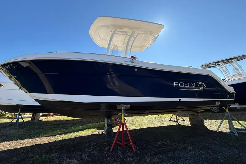 Slide: The Image of 2021 Robalo R222 Explorer boat on stands under clear blue sky. - 19