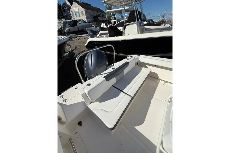 Slide: The Image of 2021 Robalo R222 Explorer boat interior with seating and motor, docked outdoors. - 3