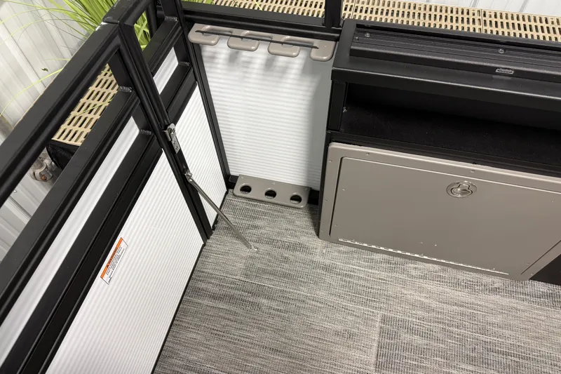 Slide: The Image of Interior of 2026 Qwest M-Class 22 Pro Sport boat, featuring storage compartments and rod holders. - 11