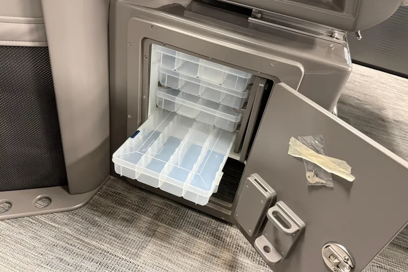 Slide: The Image of Open storage compartment in 2026 Qwest M-Class 22 Pro Sport boat, featuring organized plastic trays. - 23