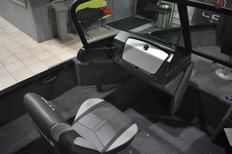 Slide: The Image of 2026 Lund 1650 Rebel XL Sport boat interior with seating and storage compartment. - 12