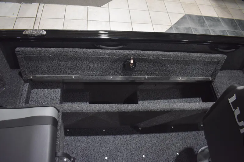 Slide: The Image of 2026 Lund 1650 Rebel XL Sport boat interior storage compartment with carpeted finish. - 15