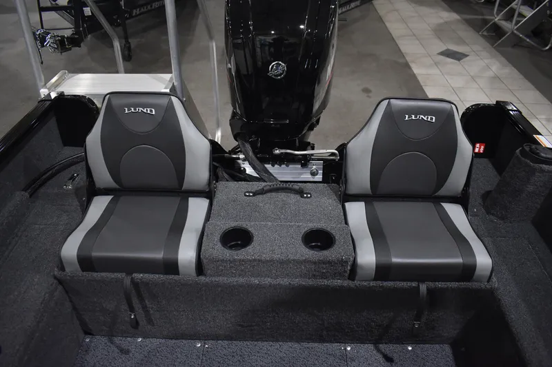 Slide: The Image of 2026 Lund 1650 Rebel XL Sport boat interior with dual seats and cup holders. - 16