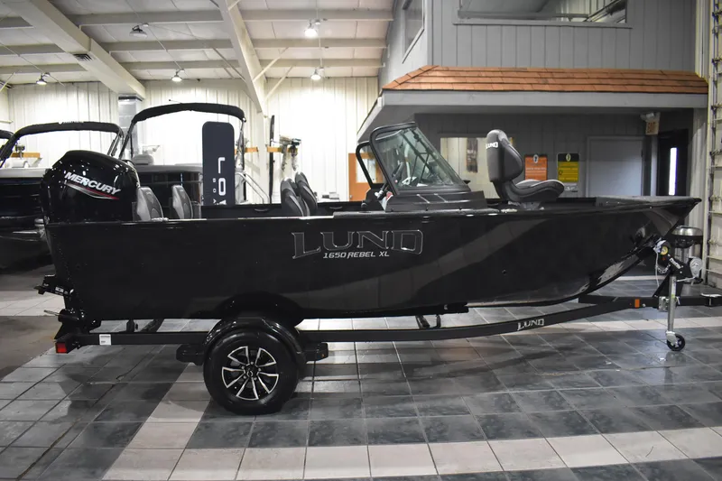 Slide: The Image of 2026 Lund 1650 Rebel XL Sport boat in showroom, side view. - 4
