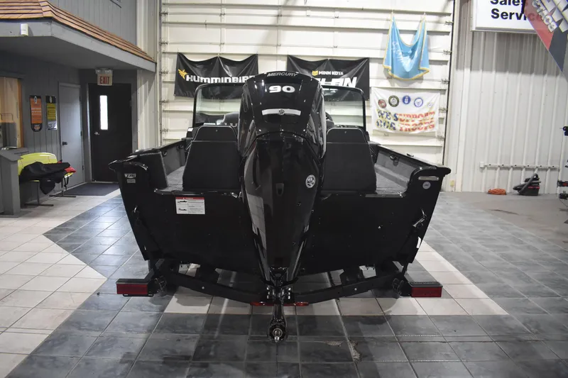 Slide: The Image of 2026 Lund 1650 Rebel XL Sport boat with Mercury 90 engine in showroom. - 6