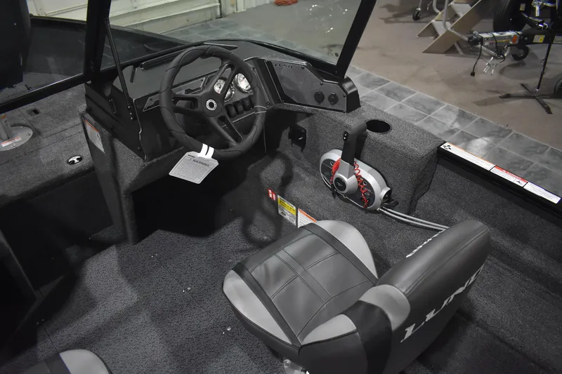 Slide: The Image of 2026 Lund 1650 Rebel XL Sport boat interior with steering wheel and seating. - 9