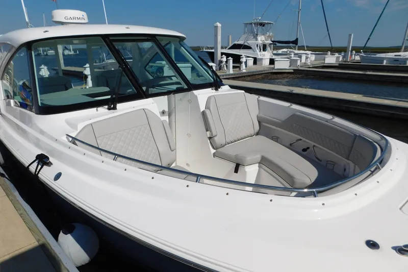 Slide: The Image of 2024 Pursuit DC 326 Dual Console boat docked, featuring spacious seating and sleek design. - 12