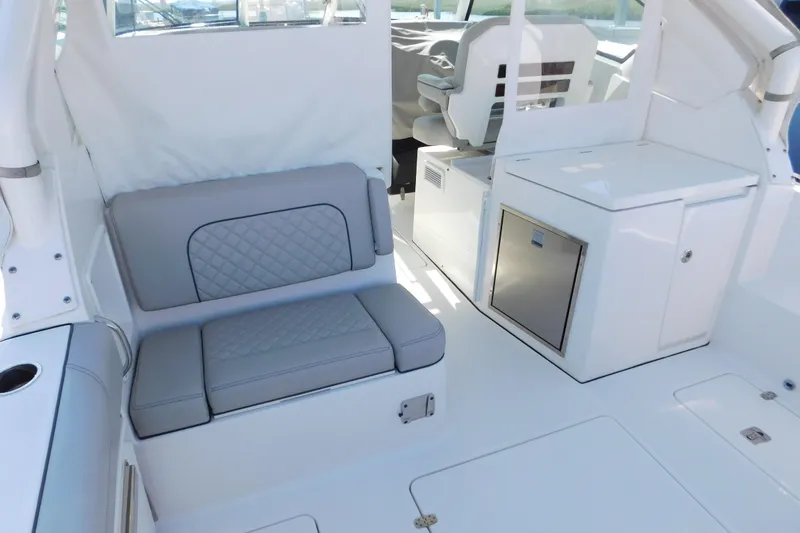 Slide: The Image of 2024 Pursuit DC 326 Dual Console interior with gray seating and storage compartments. - 16