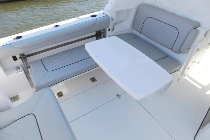 Slide: The Image of 2024 Pursuit DC 326 Dual Console boat interior with seating and table. - 19