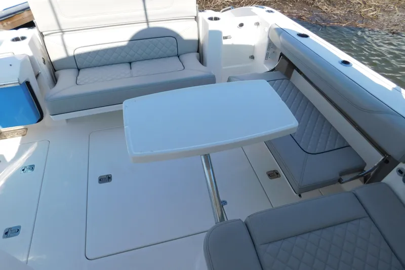 Slide: The Image of 2024 Pursuit DC 326 Dual Console boat interior with seating and table setup. - 20