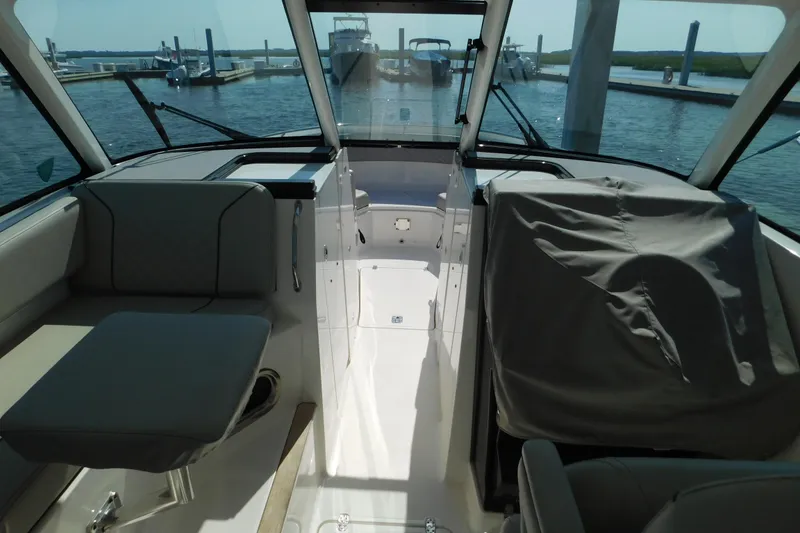Slide: The Image of 2024 Pursuit DC 326 Dual Console interior with seating, docked at marina. - 27