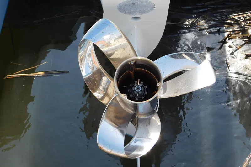 Slide: The Image of 2024 Pursuit DC 326 Dual Console boat propeller in water, showcasing shiny metal blades. - 3