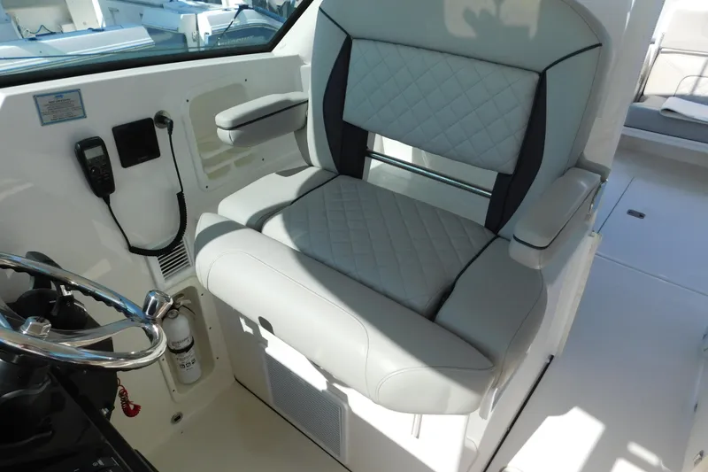 Slide: The Image of 2024 Pursuit DC 326 Dual Console boat interior with luxurious seating and steering wheel. - 33