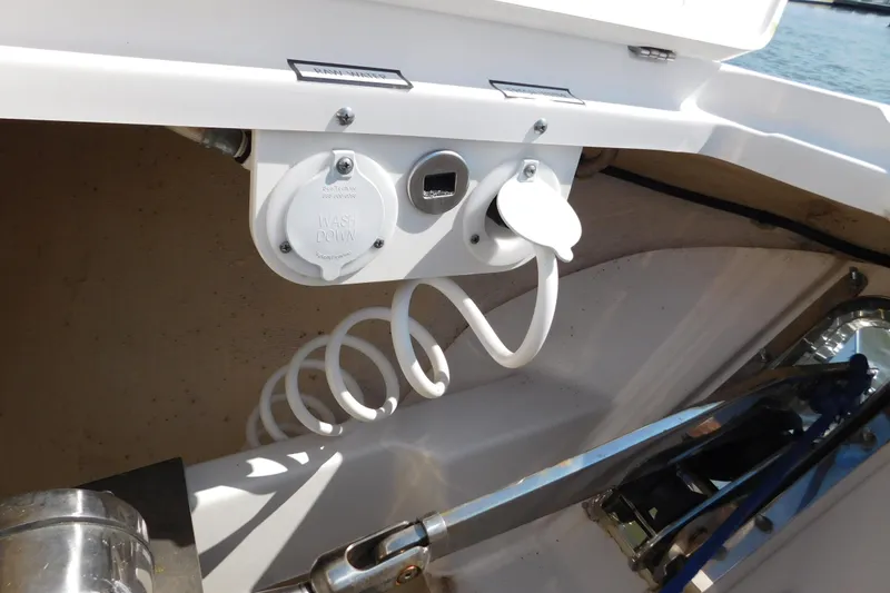 Slide: The Image of 2024 Pursuit DC 326 Dual Console boat washdown system with coiled hose. - 55