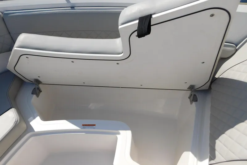 Slide: The Image of 2024 Pursuit DC 326 Dual Console boat storage compartment with open seat lid. - 58