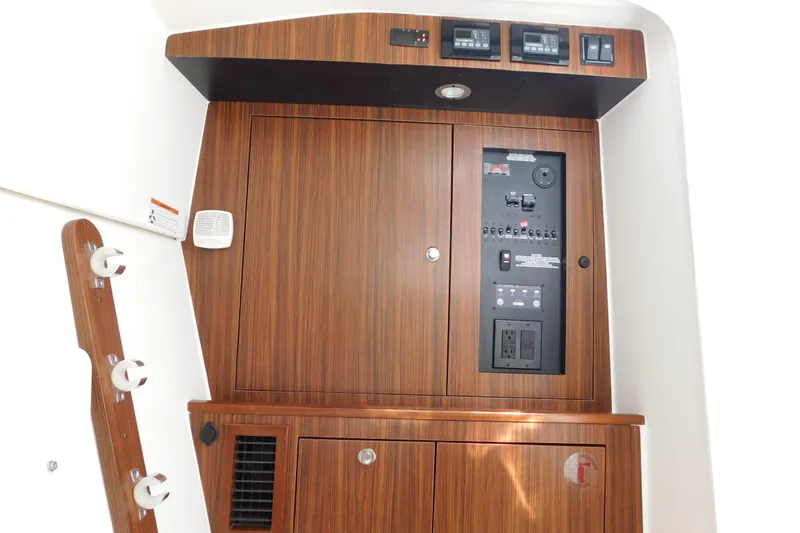 Slide: The Image of 2024 Pursuit DC 326 Dual Console interior with wood paneling and control panel. - 76