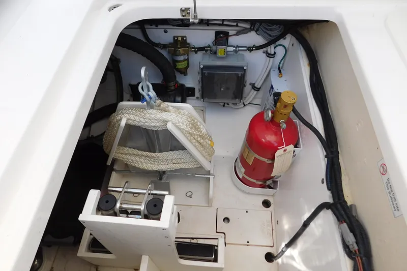 Slide: The Image of 2024 Pursuit DC 326 Dual Console storage compartment with fire extinguisher and rope. - 89