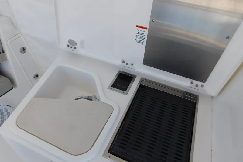 Slide: The Image of 2024 Pursuit DC 326 Dual Console boat sink and grill area. - 93