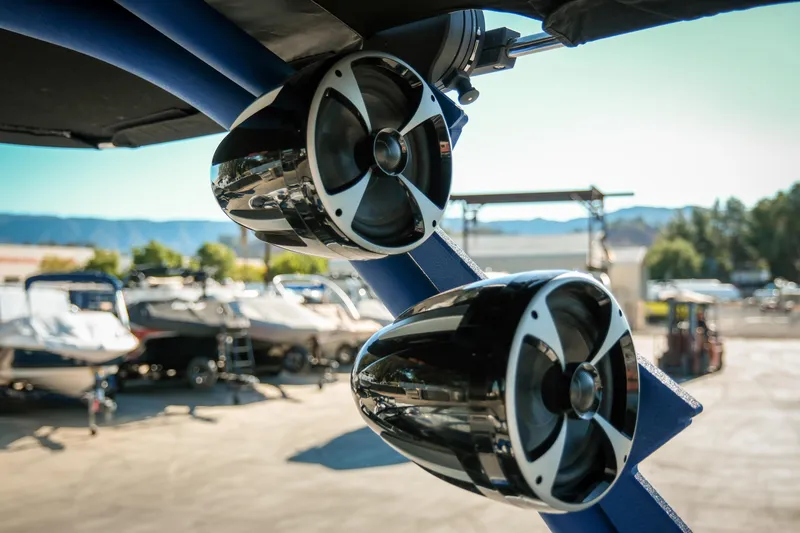Slide: The Image of 2021 Malibu Wakesetter 23 LSV speakers, close-up view, in a boatyard setting. - 16