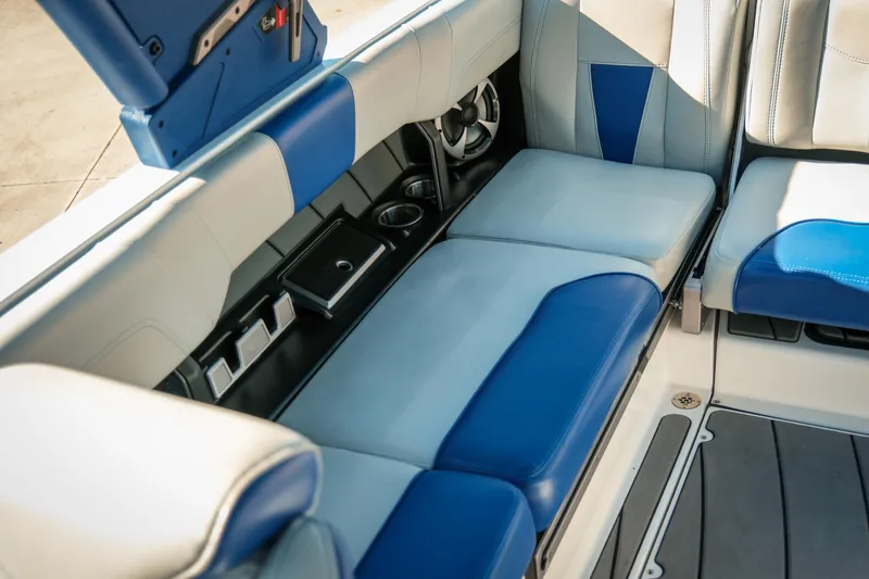 Slide: The Image of 2021 Malibu Wakesetter 23 LSV interior with blue and gray seating, cup holders, and storage. - 21