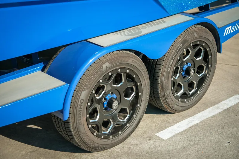 Slide: The Image of Blue Malibu Wakesetter 23 LSV 2021 trailer with stylish black wheels. - 31