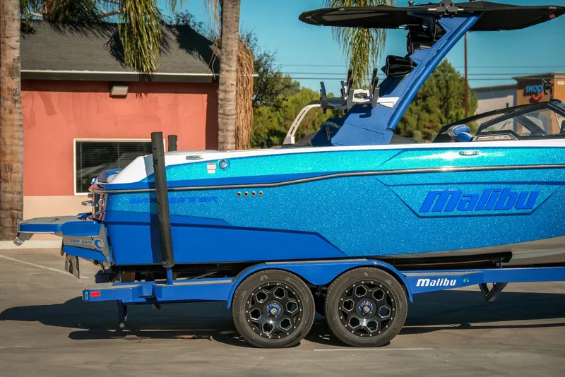 Slide: The Image of 2021 Malibu Wakesetter 23 LSV boat in vibrant blue, parked outdoors. - 7