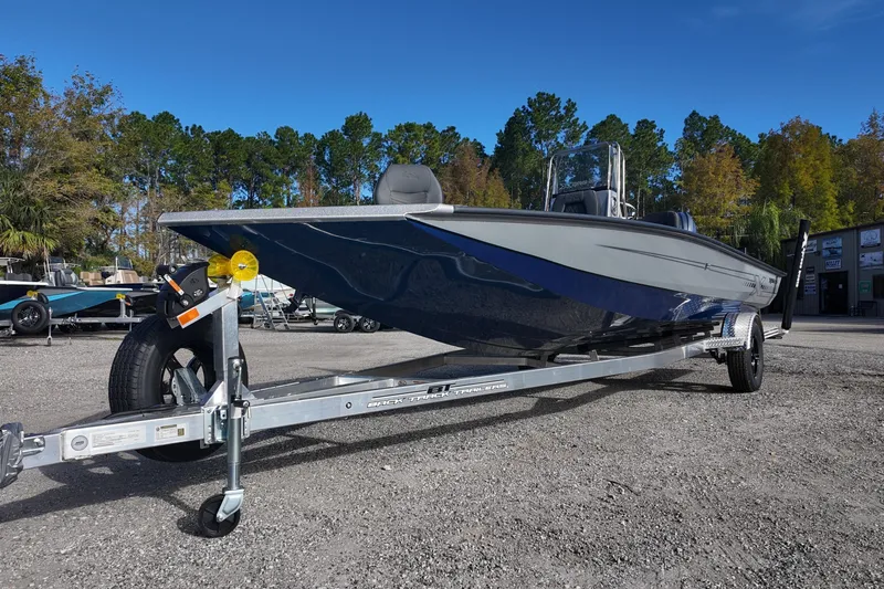 Slide: The Image of 2026 Xpress H22B Bay boat on trailer, parked outdoors with trees in background. - 3