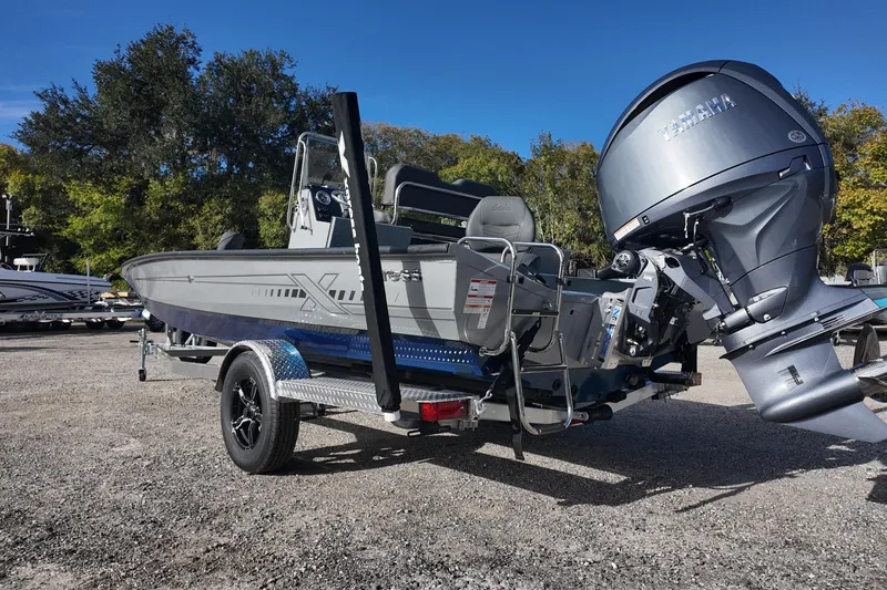 Slide: The Image of 2026 Xpress H22B Bay boat with Yamaha outboard motor on trailer, parked outdoors. - 4