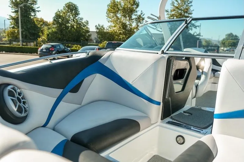 Slide: The Image of 2014 Centurion Enzo SV233 boat interior with blue and black accents, parked outdoors. - 10