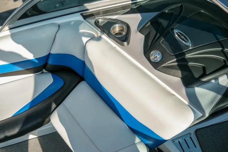 Slide: The Image of 2014 Centurion Enzo SV233 boat interior with blue and white seating, cup holder, and dashboard. - 17