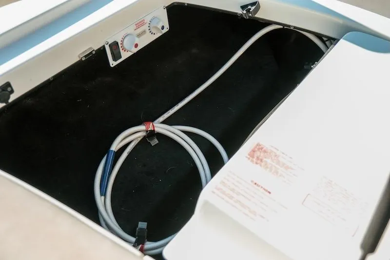 Slide: The Image of 2014 Centurion Enzo SV233 boat storage compartment with cables and control panel. - 22