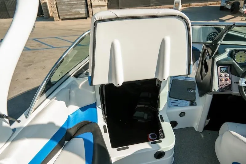 Slide: The Image of 2014 Centurion Enzo SV233 boat interior with open storage compartment and dashboard controls. - 27