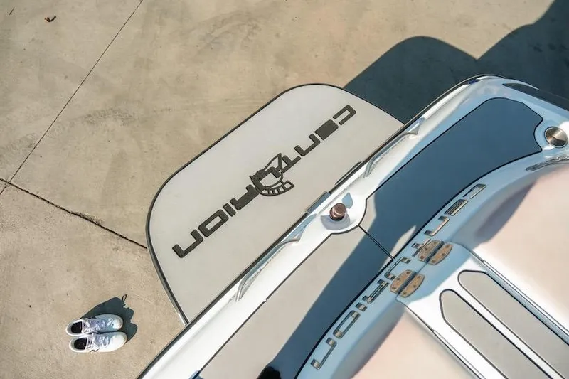 Slide: The Image of 2014 Centurion Enzo SV233 boat deck with logo, viewed from above, next to white sneakers. - 28