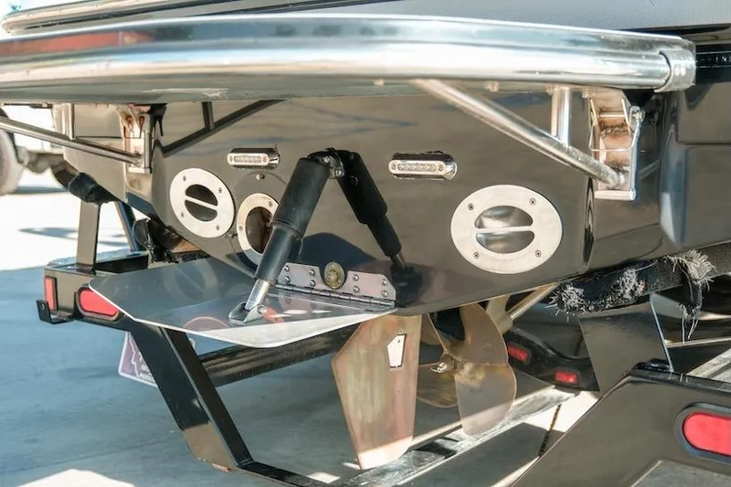 Slide: The Image of Rear view of a 2014 Centurion Enzo SV233 boat, showcasing propeller and trim tab. - 30