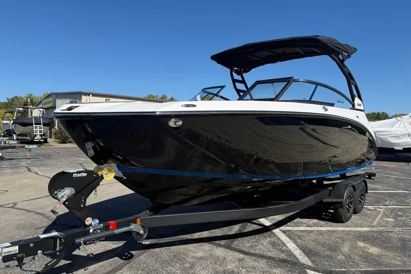 Slide: The Image of 2026 Yamaha Boats 252SD on trailer, sleek black design under clear blue sky. - 1