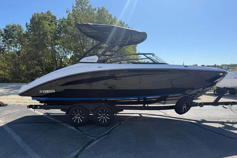 Slide: The Image of 2026 Yamaha Boats 252SD on trailer, sleek black and white design, parked outdoors. - 4