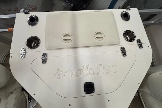 Slide: The Image of 2009 South Bay 722 FCR boat console with cup holders and storage compartment. - 15