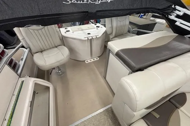 Slide: The Image of Interior of a 2009 South Bay 722 FCR boat with beige seating and helm. - 18