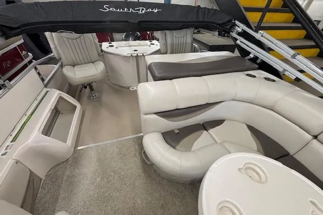 Slide: The Image of Interior of a 2009 South Bay 722 FCR pontoon boat with plush seating and table. - 19