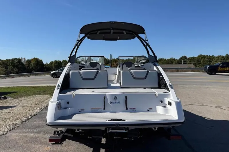 Slide: The Image of 2026 Yamaha AR250 boat, rear view, parked outdoors under clear blue sky. - 5